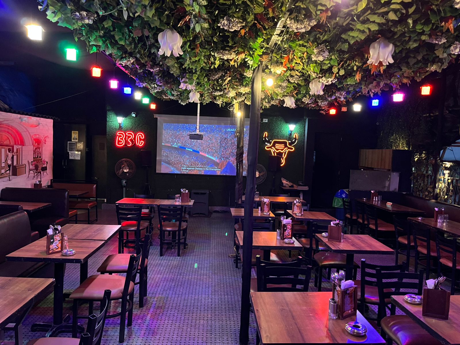 Big Bull Cafe open-air rooftop garden terrace with lush greenery planters and string lights in Andheri East